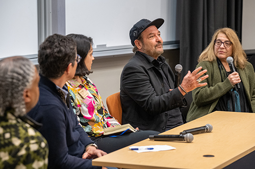 A view of the five speakers in a panel discussion in Luce Hall auditorium