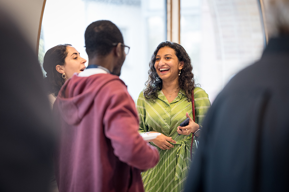 Three MacMillan students interact at the 2024 Welcome Reception