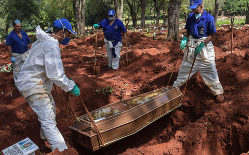 Employees bury a person suspected of dying from COVID-19 at a cemetery in the outskirts of Sao Paulo, Brazil. Photo courtesy of VOA.