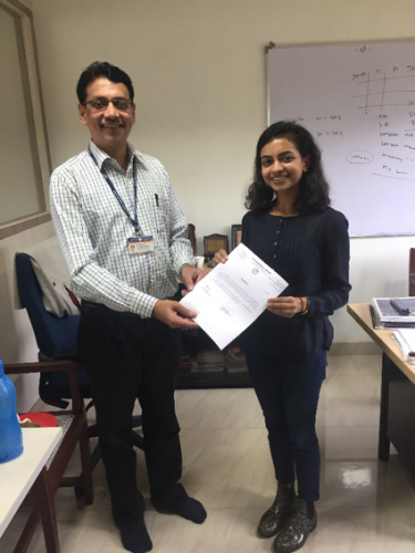 Dr. Atul Budukh presents Krisha with her certificate of completion from Tata Memorial Center.