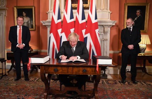 British Prime Minister Boris Johnson signing the UK-EU Trade and Cooperation Agreement as Lord David Frost, UK chief negotiator, and Sir Tim Barrow, UK ambassador to the EU, look on, December 30.