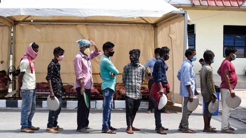 Migrants wait in queues to receive food being distributed by the volunteers outside the Railway Station during in Guwahti, Assam, 4 June, 2020. Photo by Talukdar David, Shutterstock