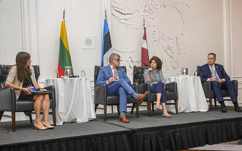 A panel discussion with the three flags of the Baltic countries behind the three ambassadors