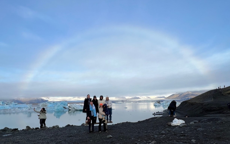 Yale's Urban Lab Iceland group stand under a rainbow with glaciers in the background