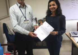 Dr. Atul Budukh presents Krisha with her certificate of completion from Tata Memorial Center.