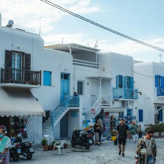 people walking on street near white and blue concrete building during daytime