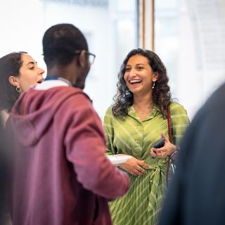 Three MacMillan students interact at the 2024 Welcome Reception