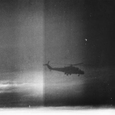 Silhouette of Military Helicopter Flying in Cloudy Sky