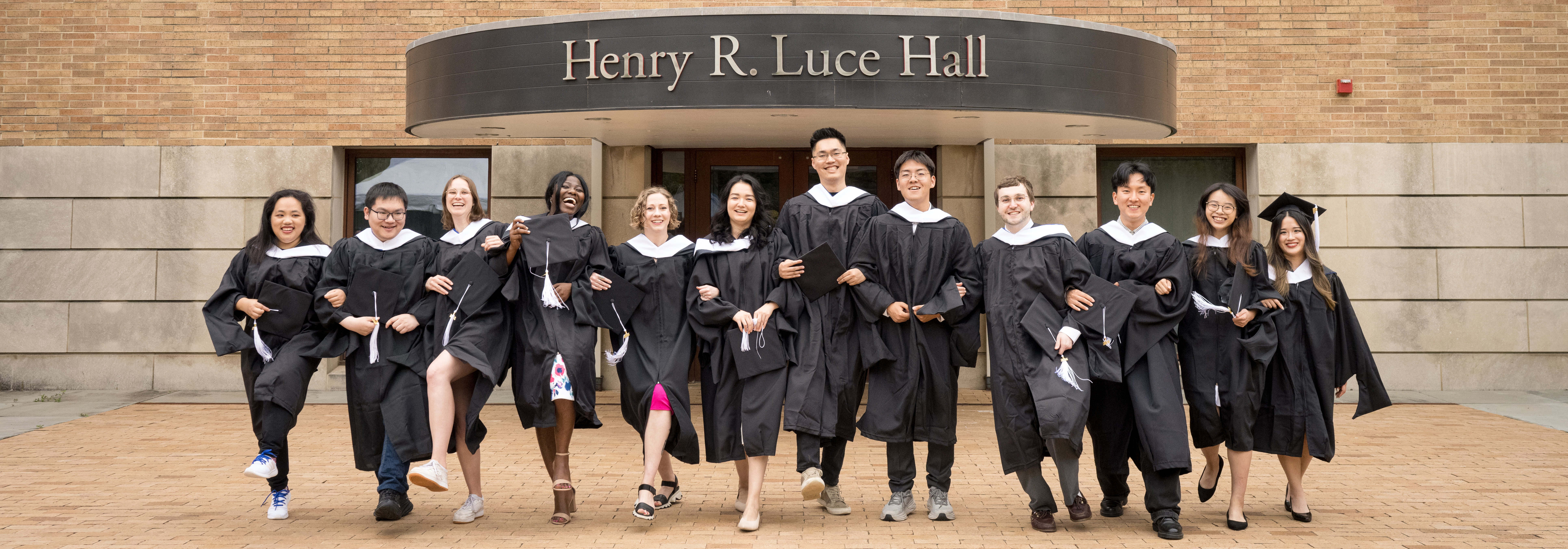 The Yale MacMillan Center's 2024 MA graduates linked arms in front of Luce Hall 