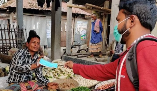 A member of the study's outreach team distributing masks in Bangladesh. Photo: IPA. 